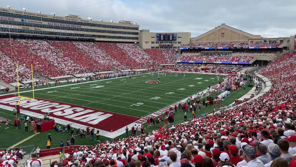 Uitzicht vanaf de tribune op het levendige en volgepakte Wisconsin college football stadion tijdens een spannende wedstrijd, met fans die hun team aanmoedigen.