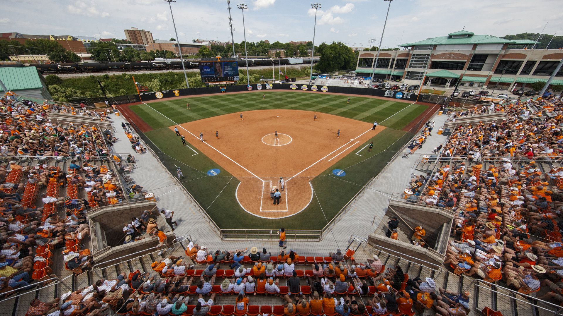Luchtfoto van een volgepakt stadion bij een college softbalwedstrijd.